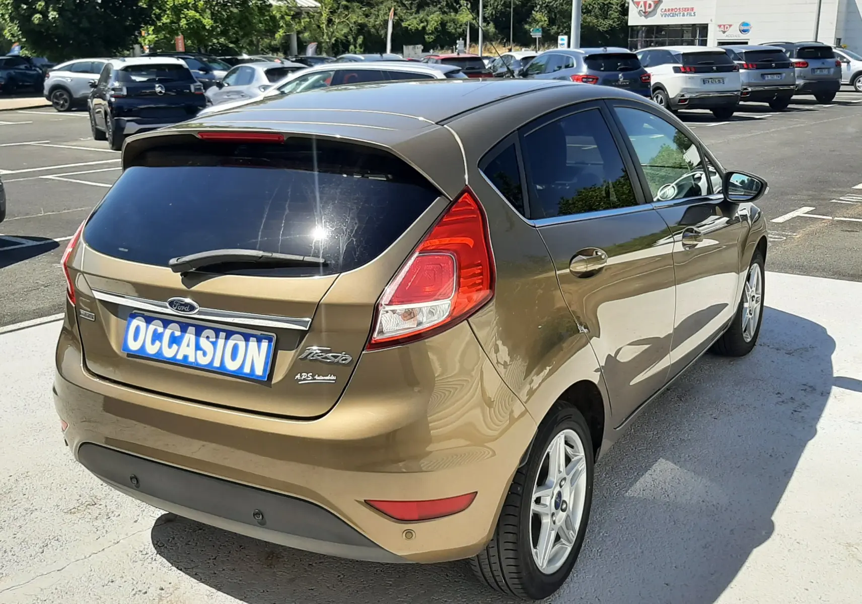 Vue 3/4 arrière droite d'une Ford Fiesta marron métal 5 portes, avec vitres teintées et jantes alliage argentées.