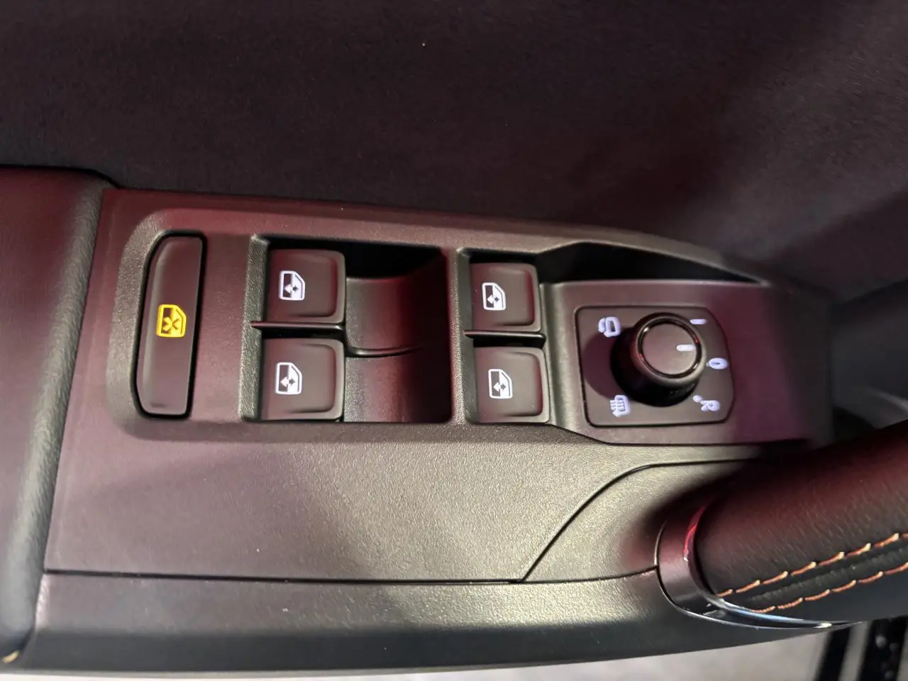 Gros plan sur les commandes de lève-vitres et réglage des rétroviseurs côté conducteur de la CUPRA Leon gris Magnetic.