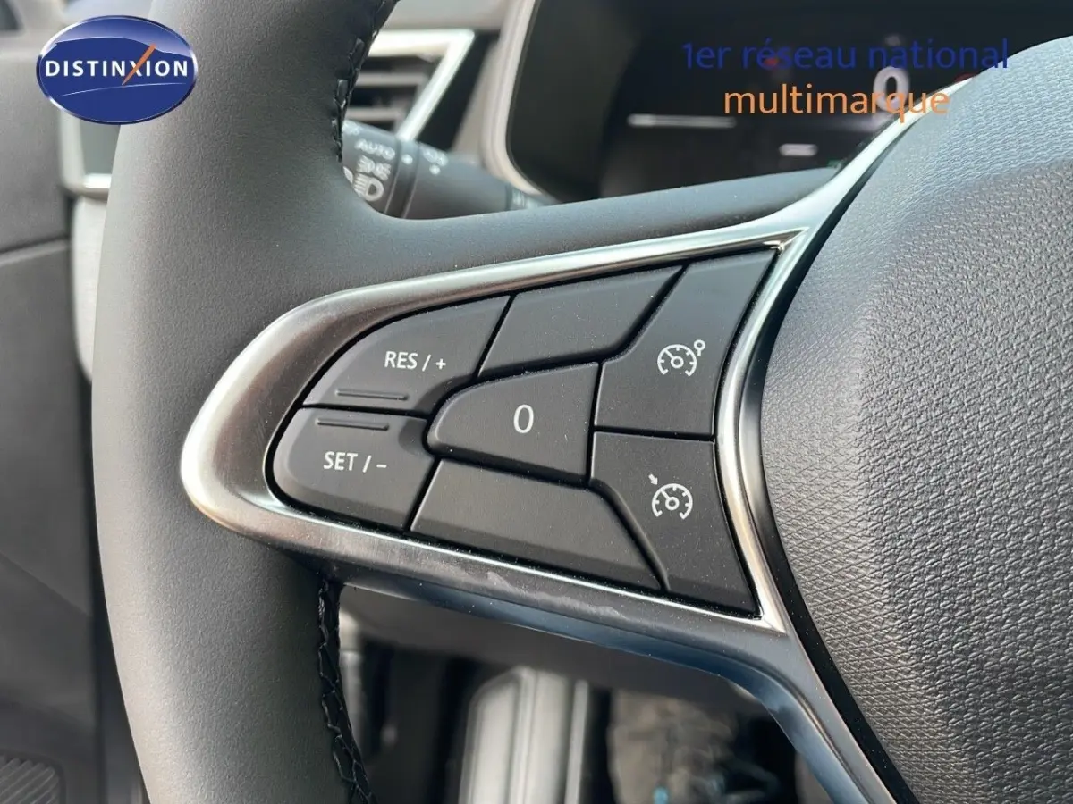 Gros plan sur les commandes du volant cuir noir de la Renault Clio Evolution Blue dCi 100, boutons de régulateur de vitesse.