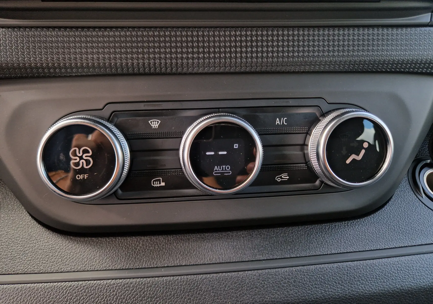 Gros plan sur les commandes de climatisation du Renault Trafic cabine approfondie blanc, avec réglages circulaires et affichage digital.