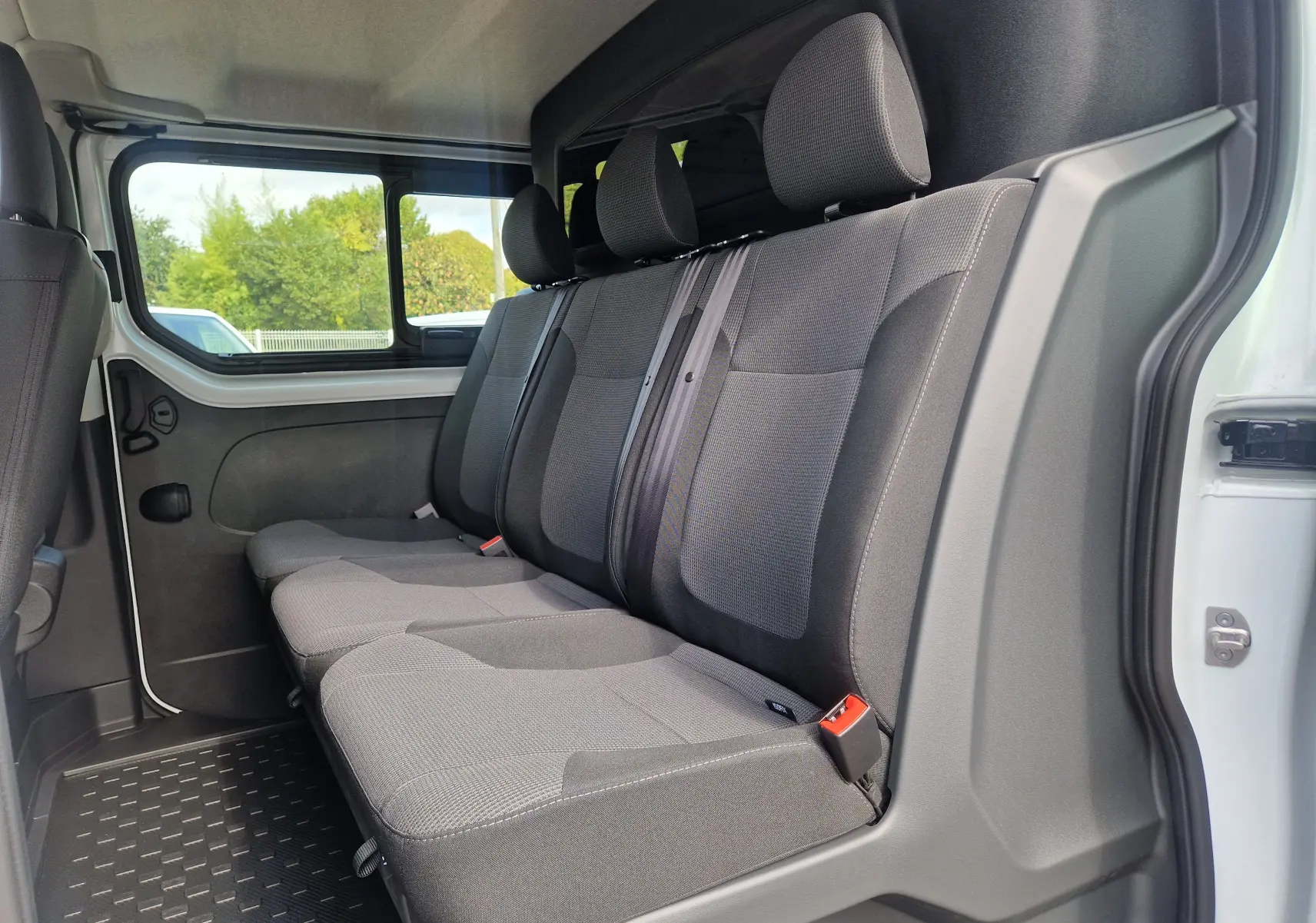 Vue intérieure côté droit des sièges arrière gris du Renault Trafic Cabine Approfondie blanc, version 6 places.