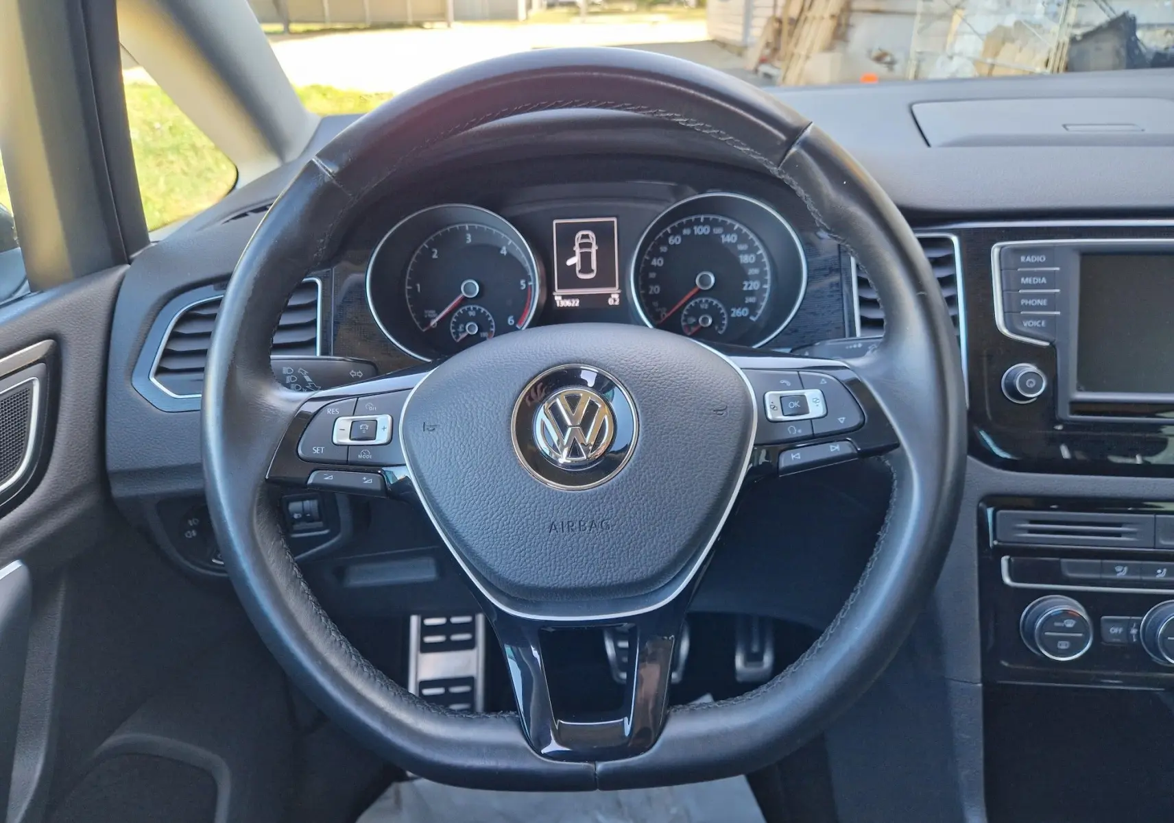 Vue frontale du volant en cuir noir du Volkswagen Golf Sportsvan 2017 avec tableau de bord et écran central visibles.