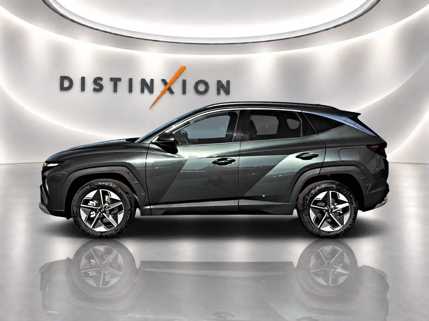 Vue profil droit du Hyundai Tucson 1.6 t-gdi 239 hybride vert métallisé avec jantes alu 18 pouces dans un showroom.