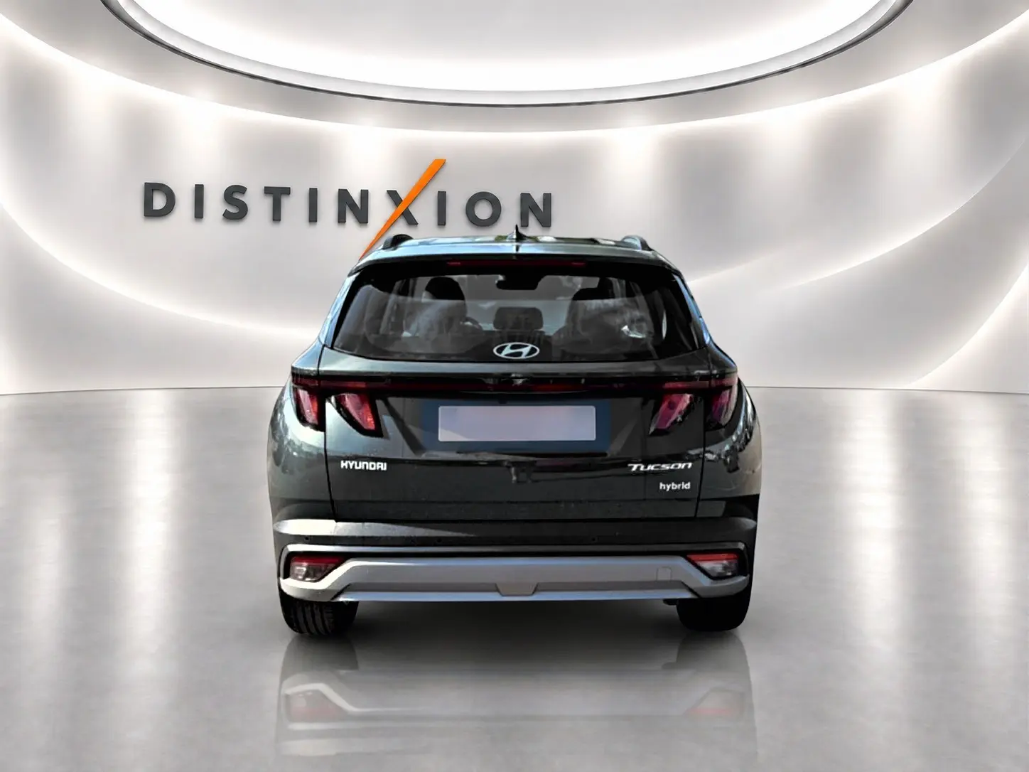 Vue arrière d'un Hyundai Tucson vert hybride 2026 dans un showroom avec logo Distinxion en fond.