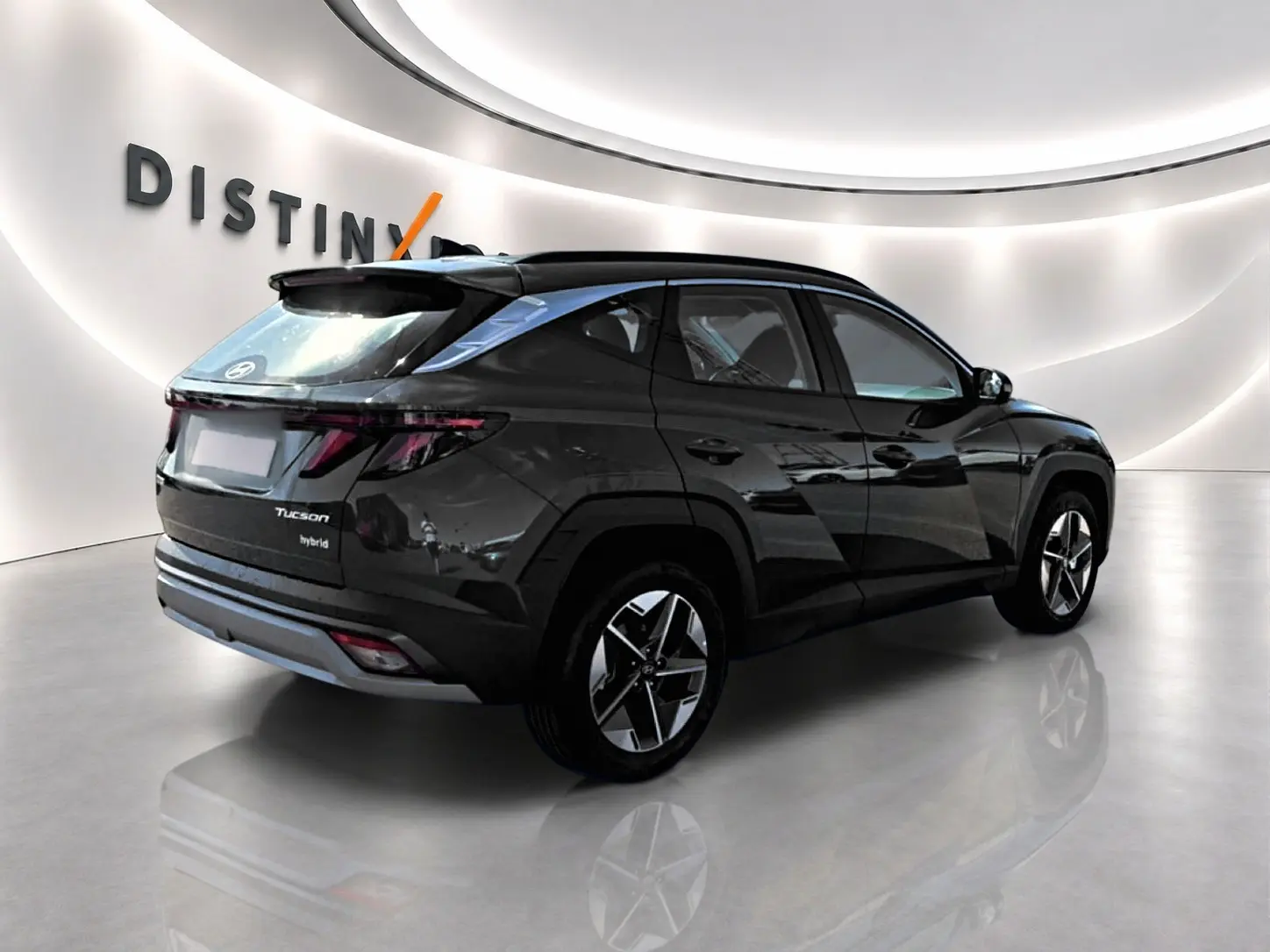 Vue 3/4 arrière droite d'un Hyundai Tucson hybride vert foncé avec jantes alliage et feux arrière LED.