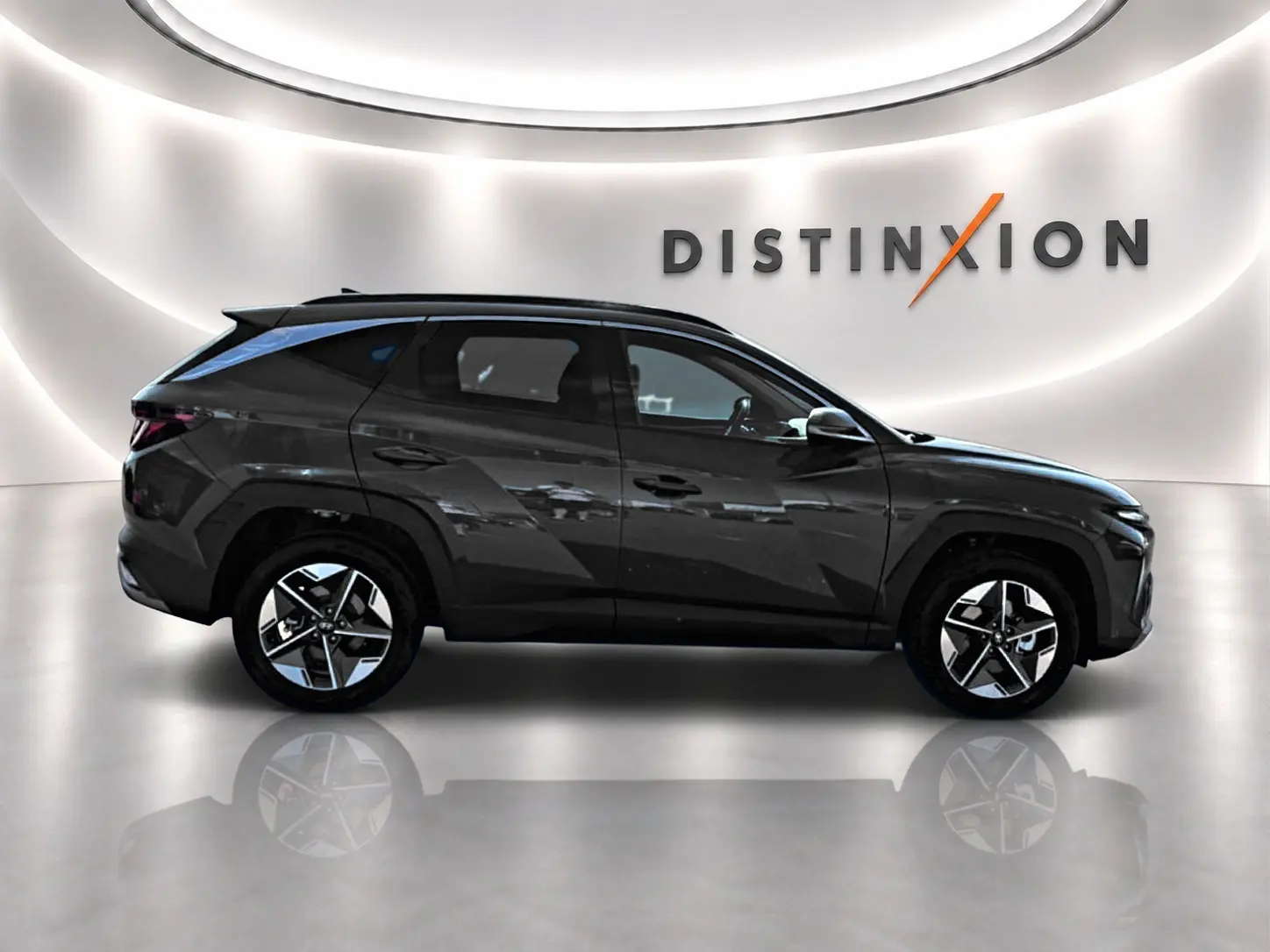 Vue de profil côté gauche d'un Hyundai Tucson vert foncé avec jantes alliage et lignes anguleuses marquées.