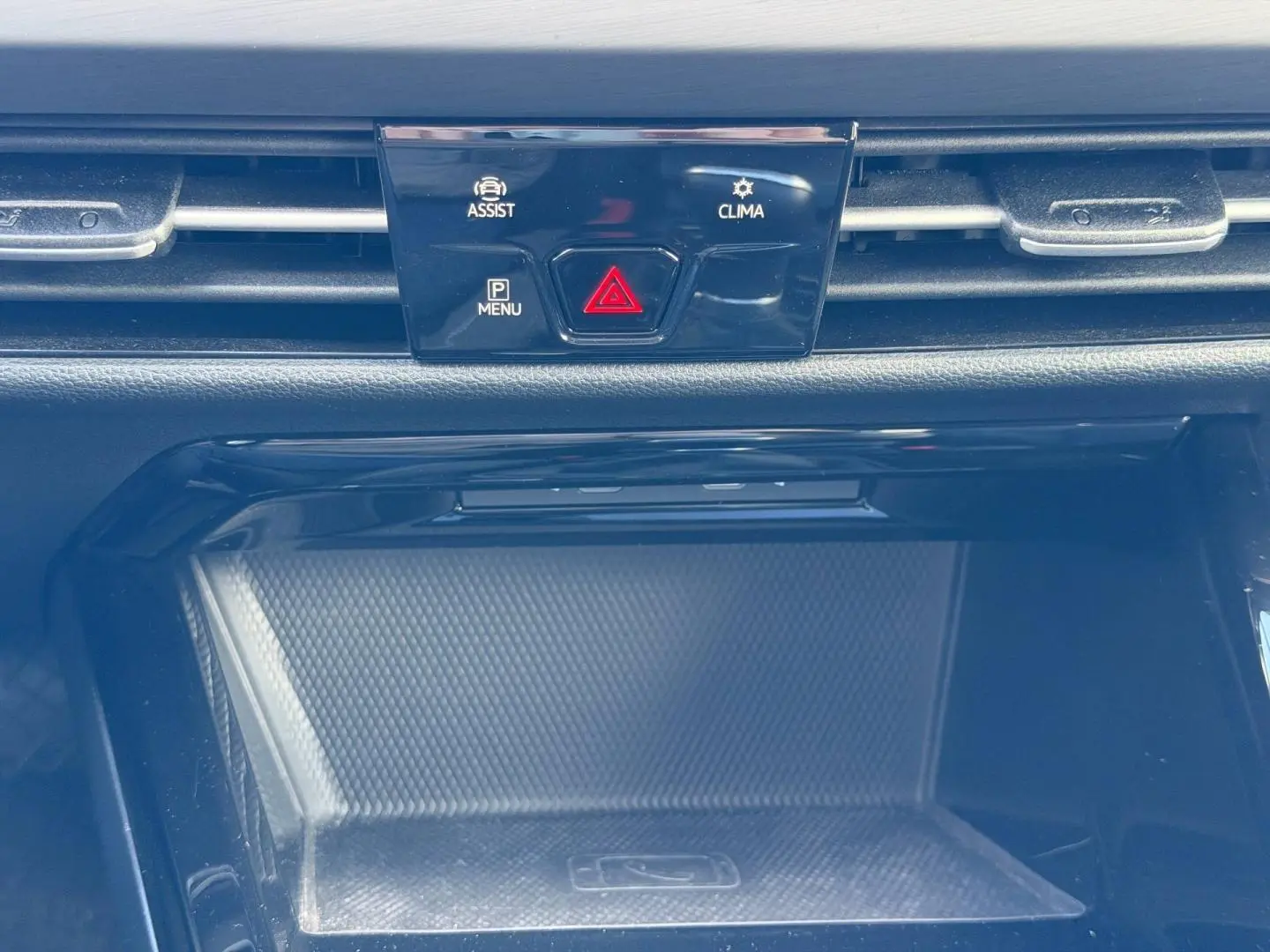 Détail de la console centrale d’une Volkswagen Golf 2024 gris lunaire, avec boutons d’assistance et climatisation.