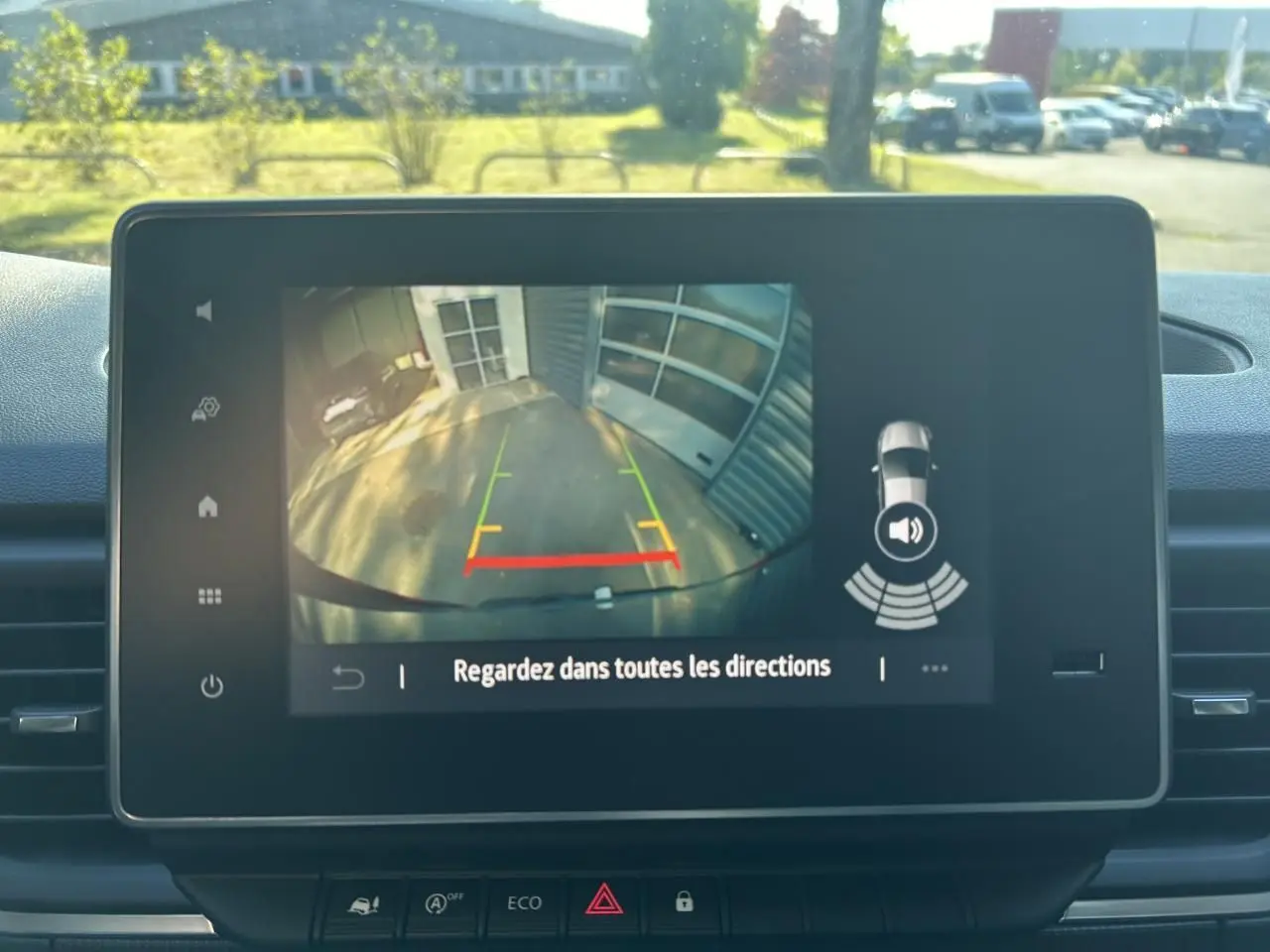Écran central montrant la caméra de recul active du Renault Trafic Fourgon gris urbain avec guidage de trajectoire coloré.