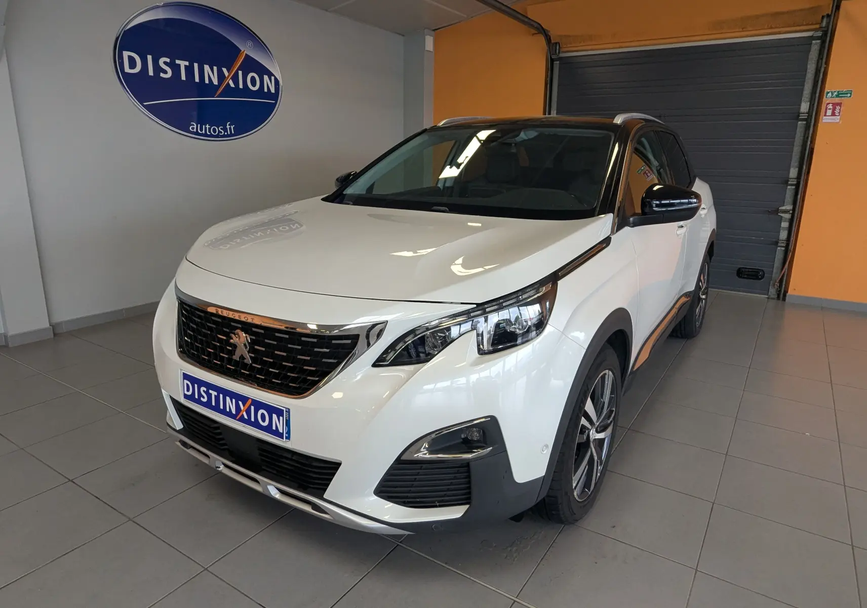 Peugeot 3008 HDi 130 Allure blanc toit noir vue 3/4 avant droit en intérieur avec logo Distinxion.