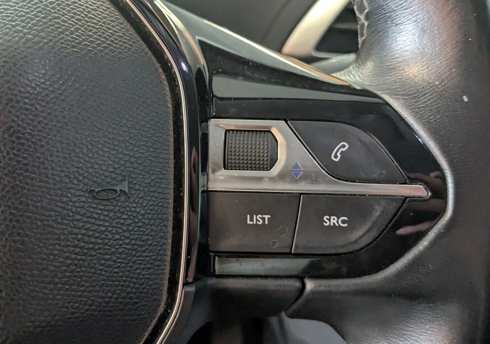 Gros plan sur les commandes multifonctions à droite du volant en cuir noir du Peugeot 3008 blanc toit noir, version HDi 130 Allure.