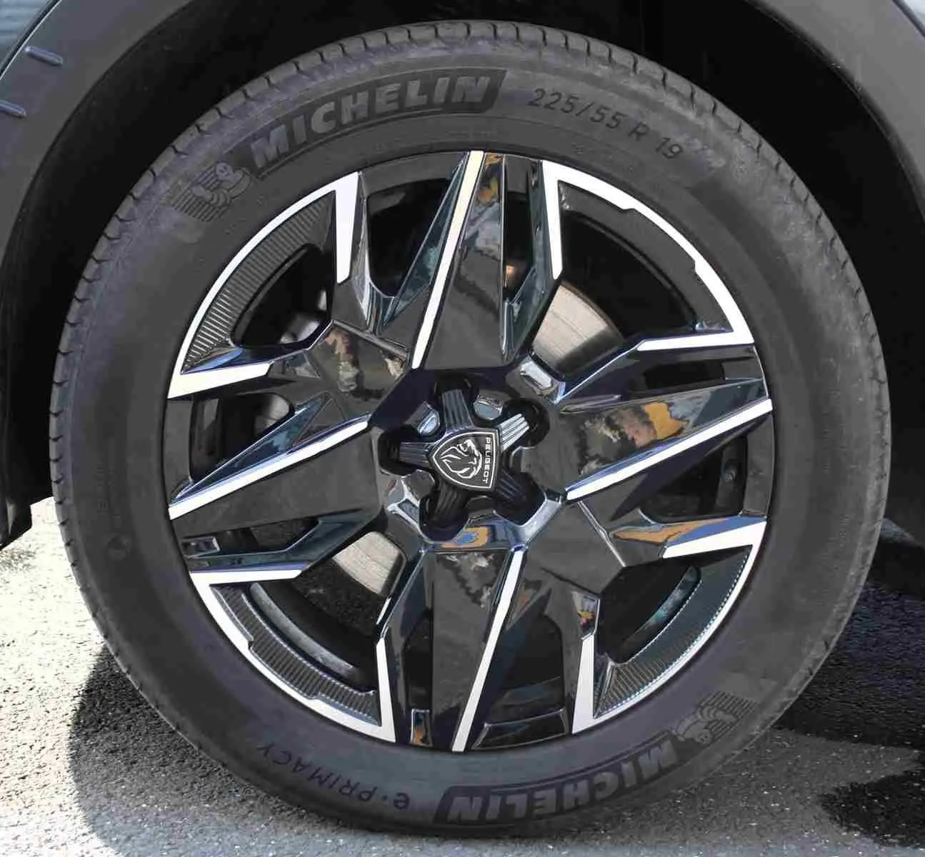 Gros plan sur la jante alliage noire et argentée du Peugeot 5008 gris titane, mettant en valeur le logo central et le pneu Michelin.