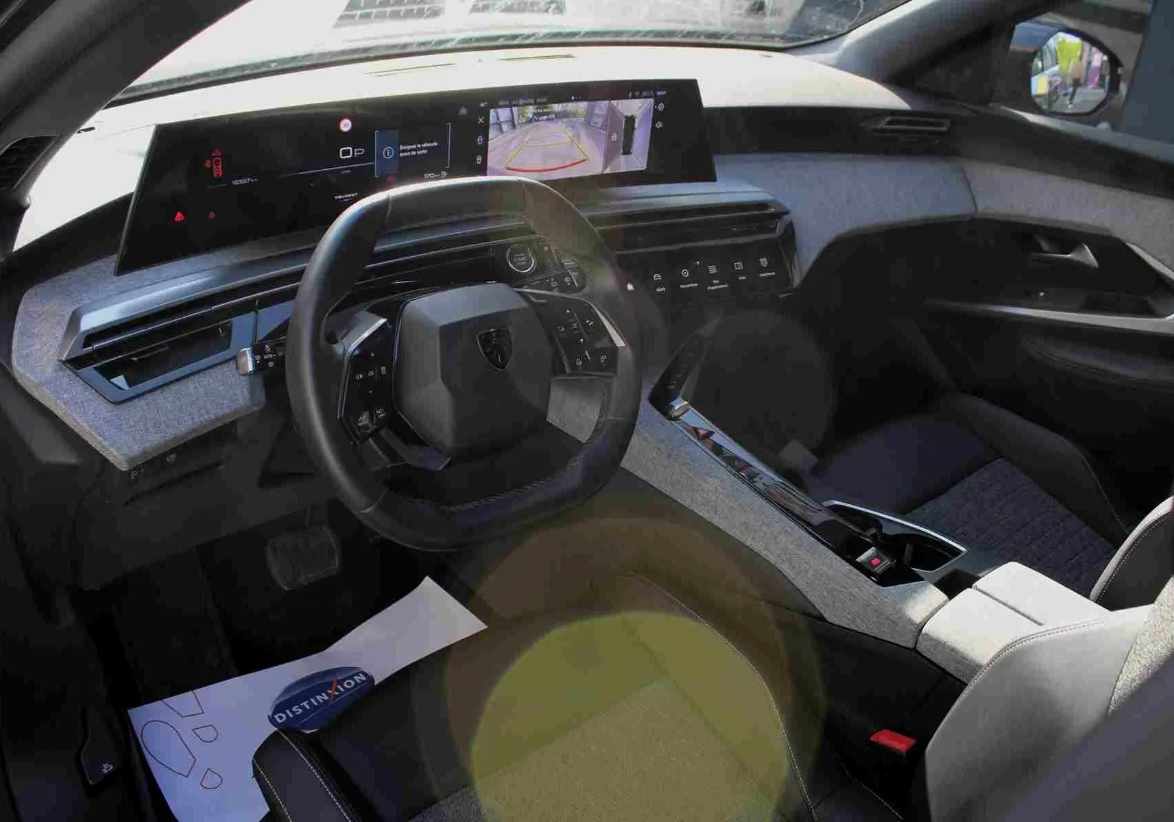 Vue intérieure côté conducteur du Peugeot 5008 gris titane, mettant en valeur le tableau de bord numérique et le volant compact.