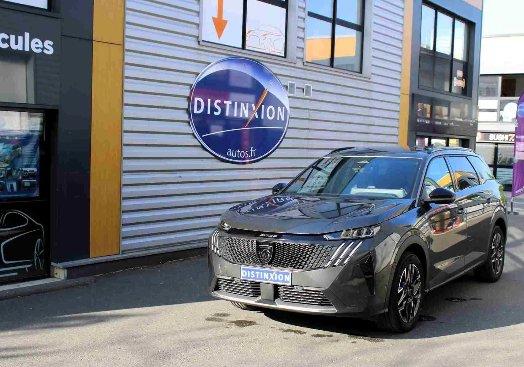 Peugeot 5008 gris titane métal vue 3/4 avant, mettant en valeur sa calandre distinctive et ses phares LED fins.