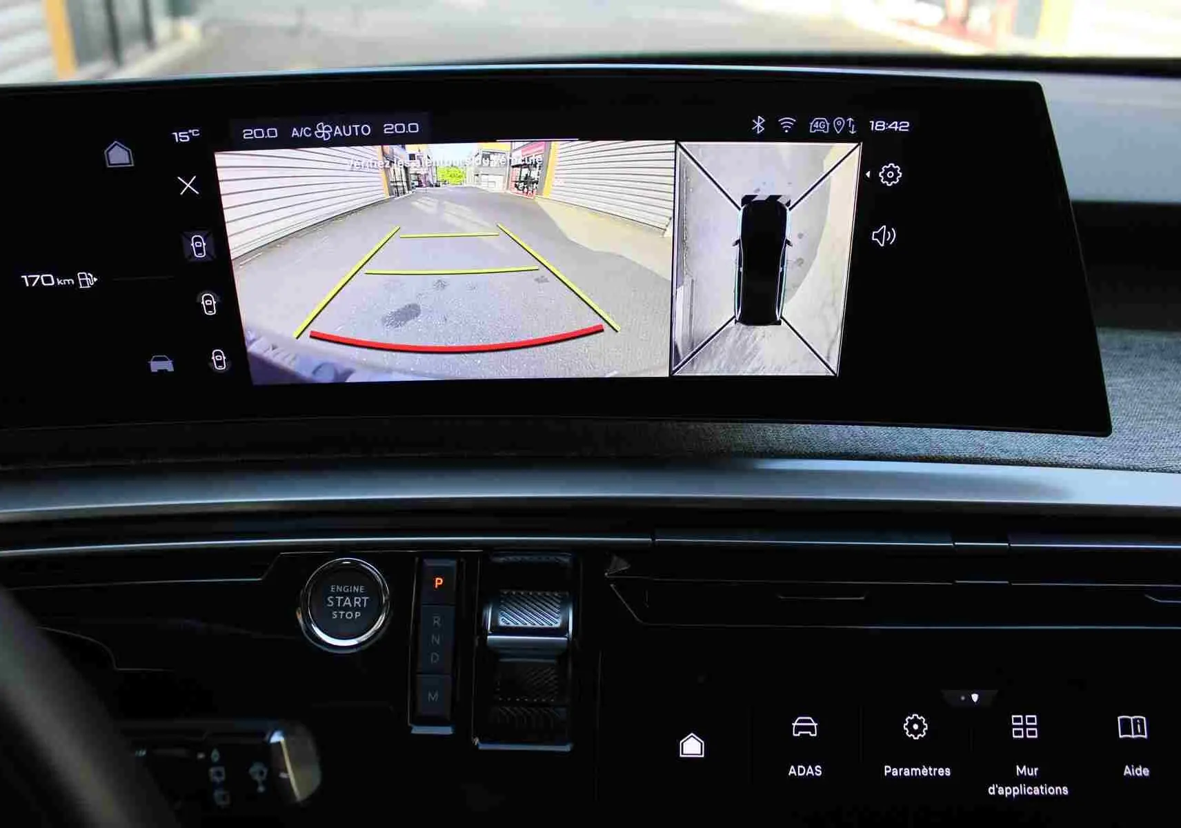 Vue rapprochée de l’écran central du Peugeot 5008 Hybrid 2025 montrant la caméra de recul et la vue à 360° en mode stationnement.