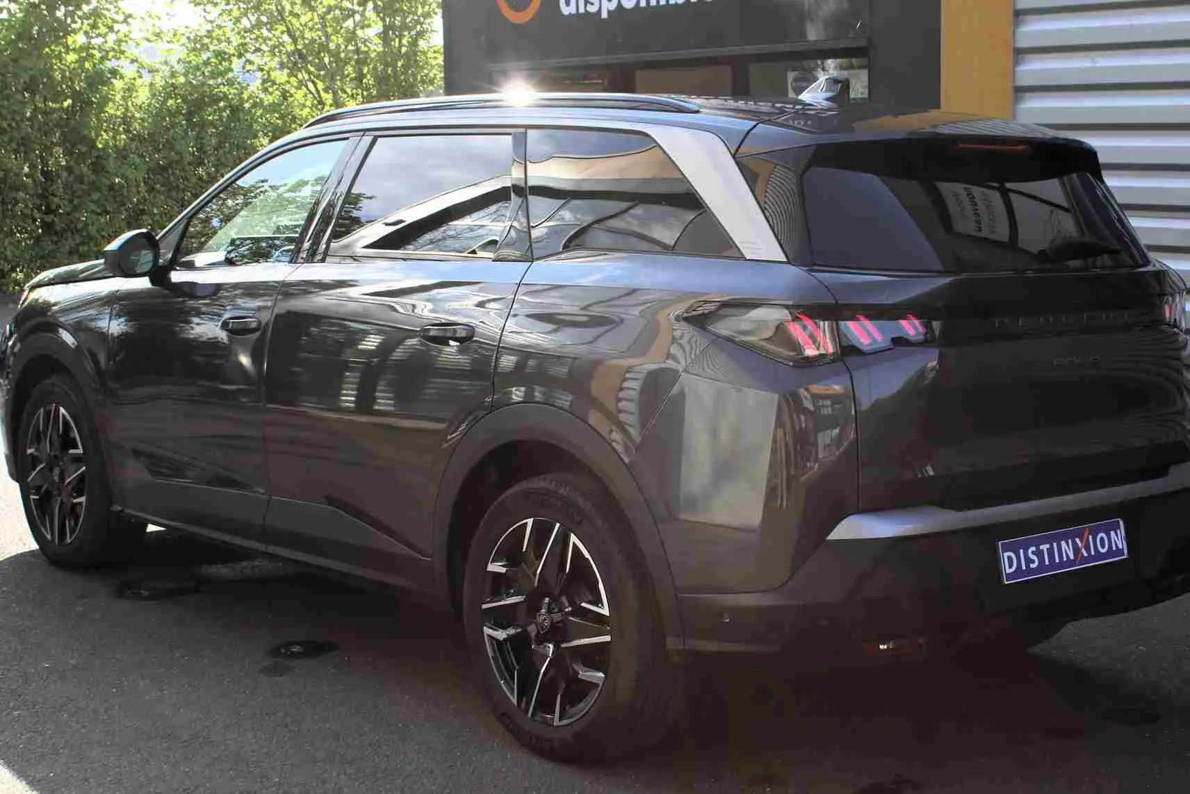 Peugeot 5008 gris titane métal en 3/4 arrière droit, avec jantes noires et toit contrasté argenté.