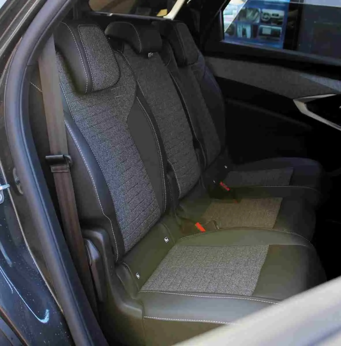 Vue latérale des sièges arrière gris noir en tissu et cuir du Peugeot 5008 III Hybrid 2025, avec ceinture de sécurité visible.
