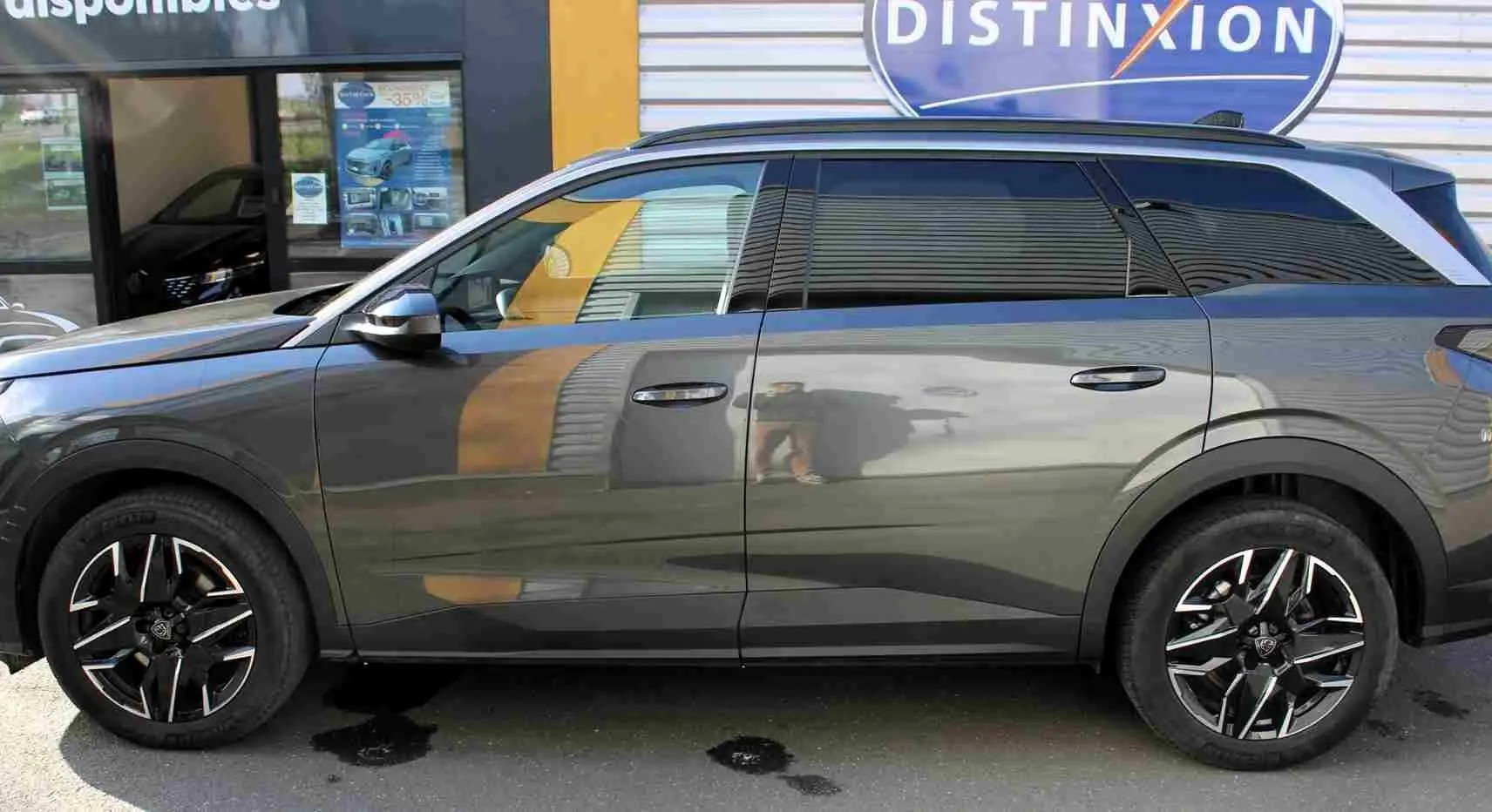 Vue latérale droite du Peugeot 5008 gris titane métal 2025 avec jantes alliage noires et toit noir contrasté.