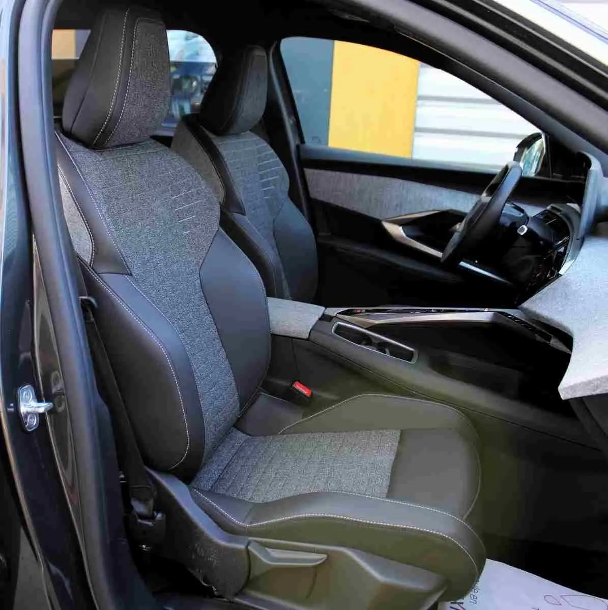 Vue intérieure côté conducteur du Peugeot 5008 gris titane, sièges bi-matière tissu et cuir avec surpiqûres blanches.