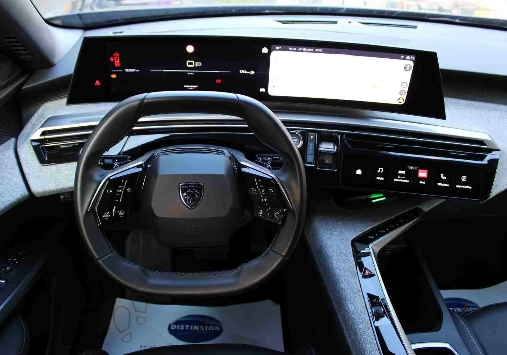 Vue intérieure frontale du tableau de bord et volant noir du Peugeot 5008 Hybrid 2025 avec écrans numériques larges.