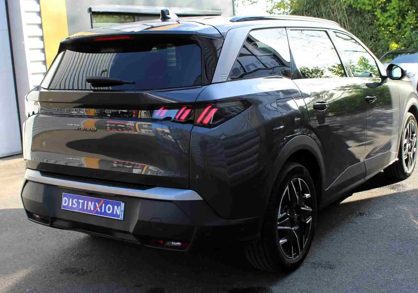 Vue 3/4 arrière droite d’un Peugeot 5008 gris titane métallisé avec feux arrière à griffes LED distinctifs.