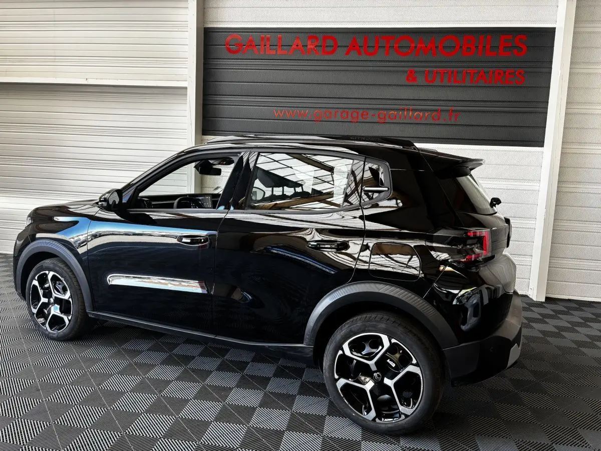 Vue de profil côté gauche d'une Citroën C3 Turbo 100 BVM6 MAX noire avec jantes bicolores et toit noir brillant.