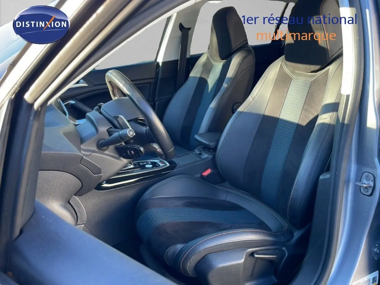 Vue intérieure côté conducteur de la Peugeot 308 gris Artense, mettant en valeur les sièges en cuir noir et alcantara.