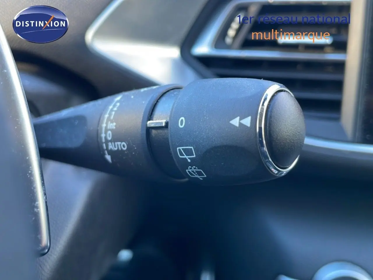 Gros plan sur la commande d’essuie-glace à gauche du volant dans l’habitacle d’une Peugeot 308 gris Artense 2019.