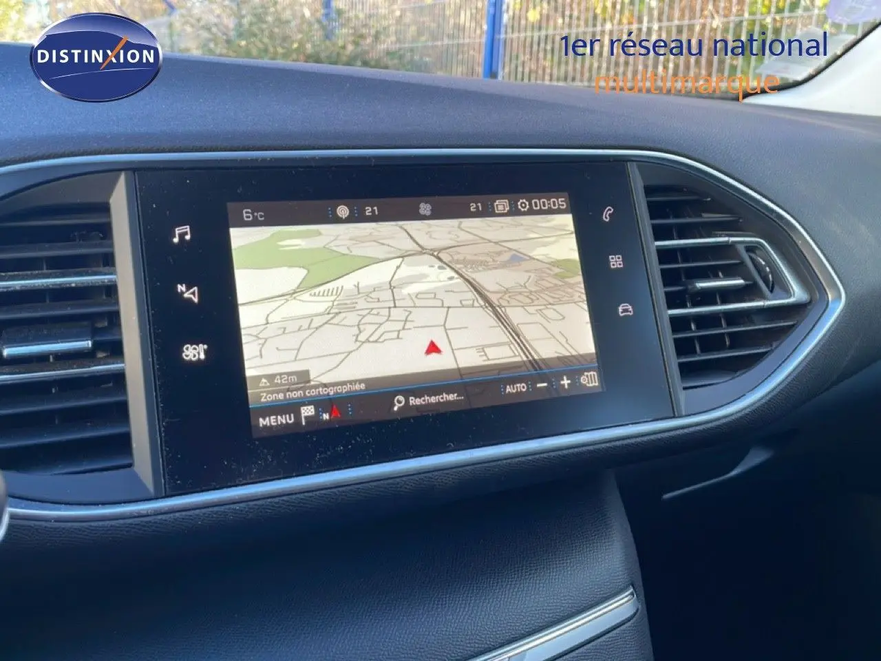 Écran tactile central du tableau de bord de la Peugeot 308 gris Artense, affichant la navigation GPS en extérieur.