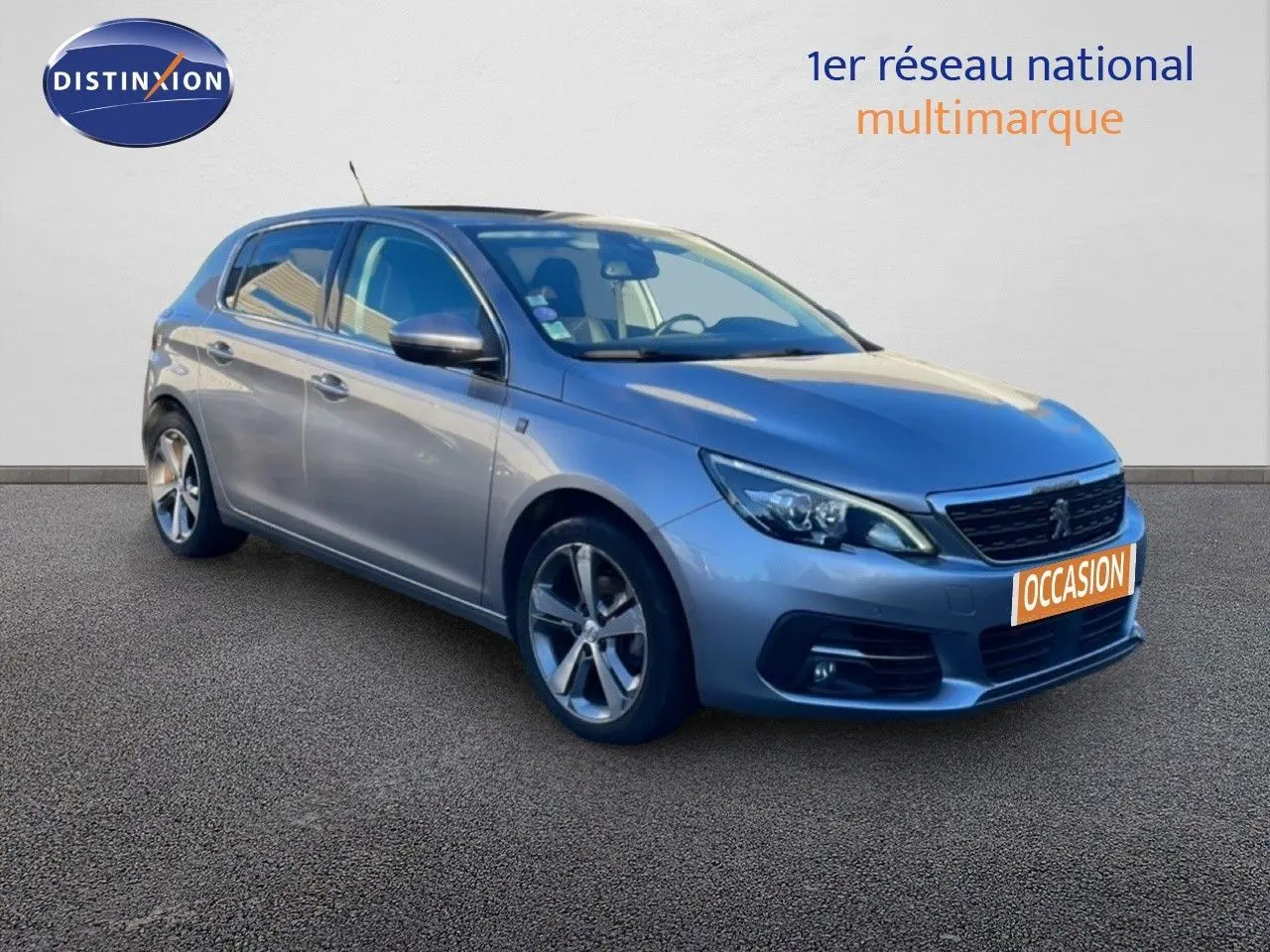 Peugeot 308 gris Artense métal vue 3/4 avant droit avec jantes alliage et calandre noire brillante.