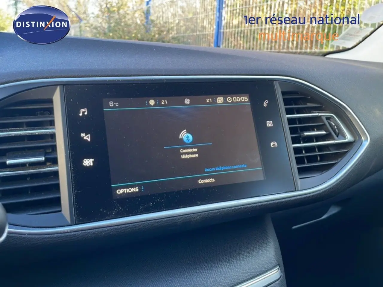 Écran tactile central du tableau de bord de la Peugeot 308 gris Artense, avec commandes multimédia et aérateurs latéraux.