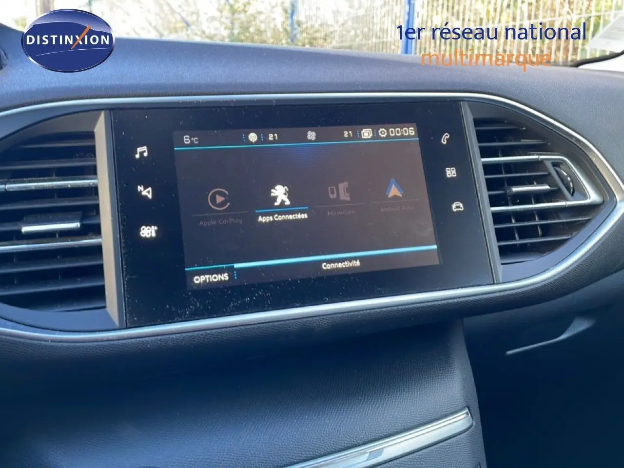 Vue rapprochée de l’écran tactile central du tableau de bord de la Peugeot 308 gris Artense, affichant les options de connectivité.