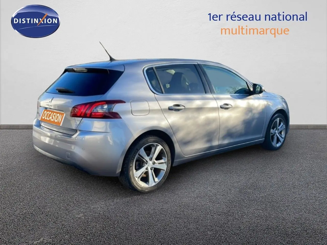 Peugeot 308 gris Artense métal vue 3/4 arrière côté droit, avec jantes alliage et vitres teintées.