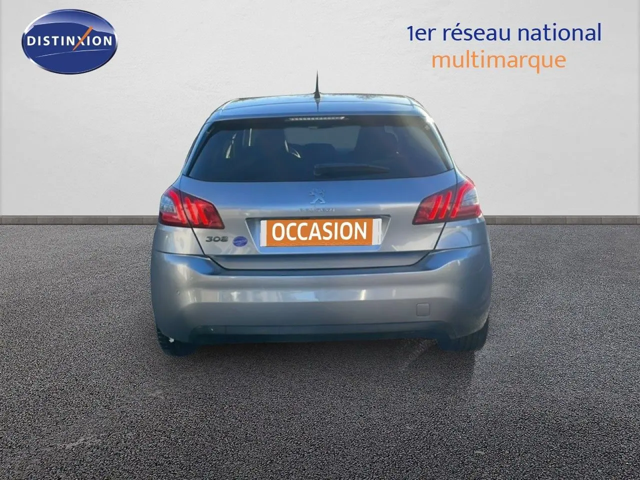 Vue arrière d'une Peugeot 308 gris Artense métal de 2019 avec plaque d'immatriculation orange "OCCASION".