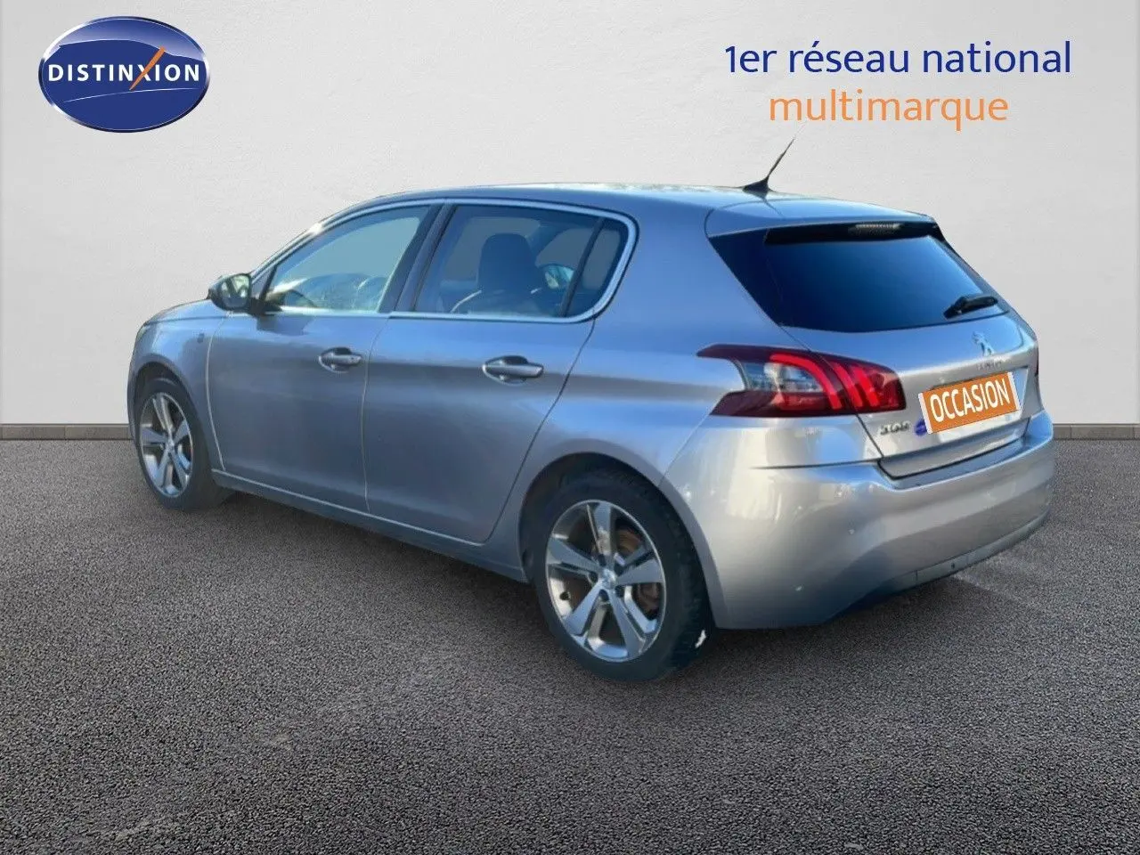 Peugeot 308 gris Artense métal vue 3/4 arrière droit, hayon fermé et jantes alliage visibles.