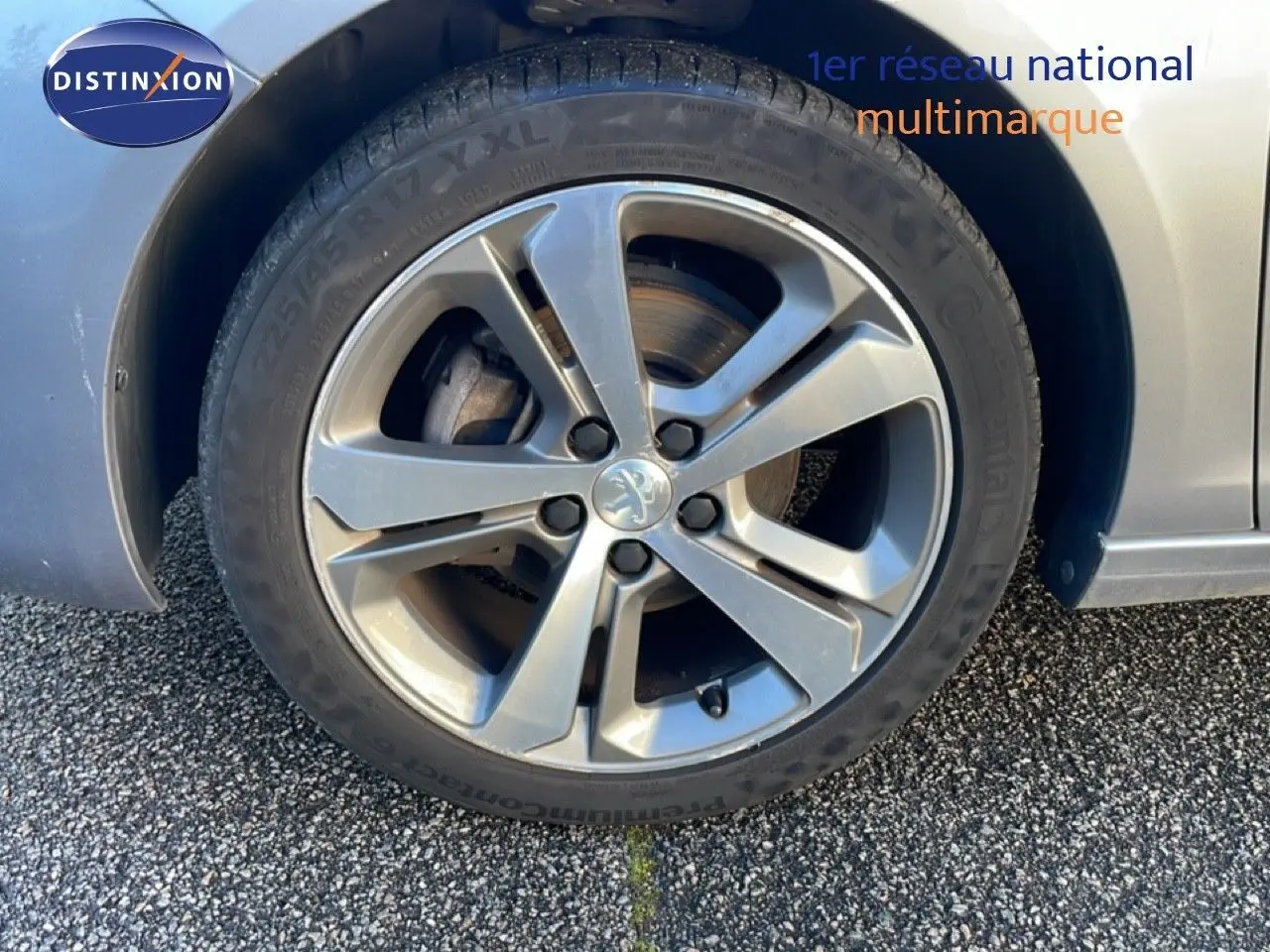 Gros plan sur la roue avant droite d’une Peugeot 308 gris Artense avec jante alliage 17 pouces.