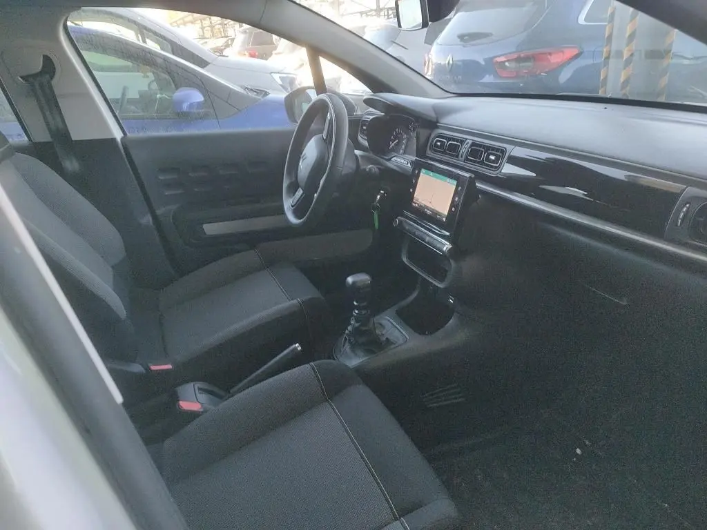 Intérieur de la Citroën C3 Société 2021 vu côté gauche, tableau de bord noir avec écran tactile et sièges tissu gris.