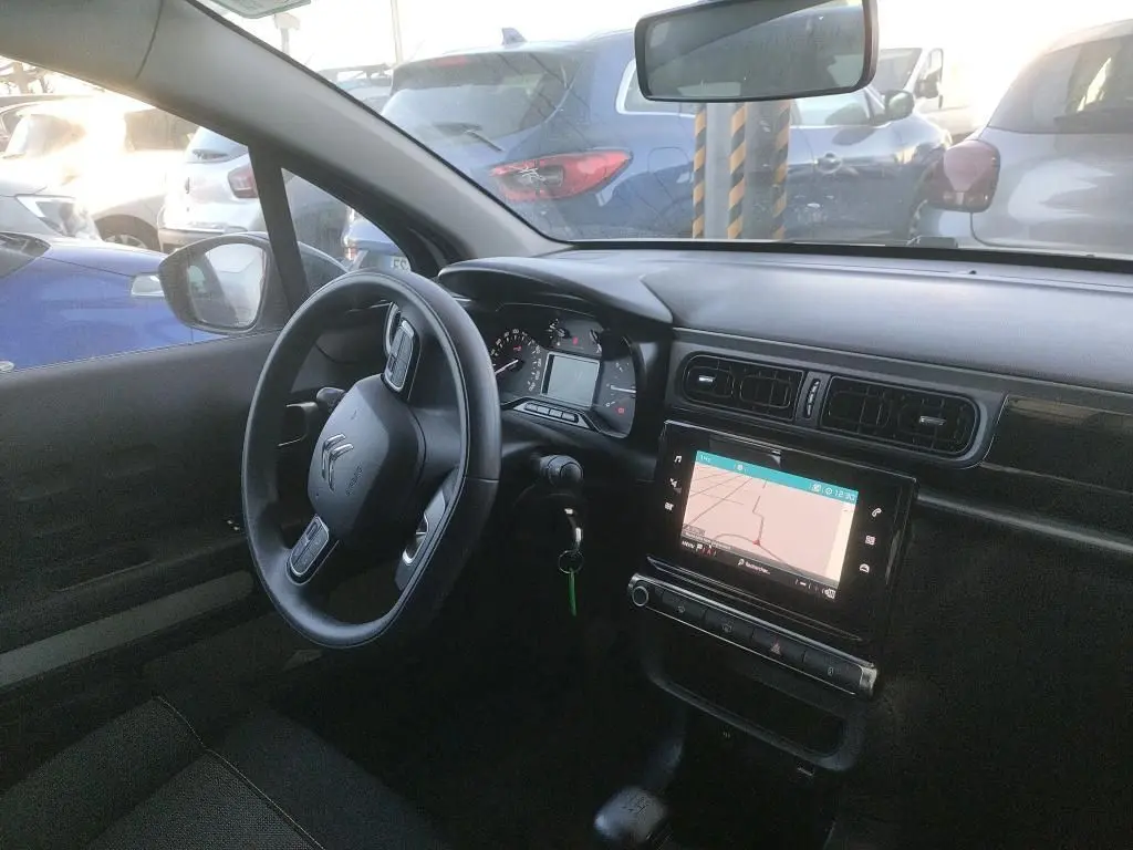 Vue intérieure côté conducteur de la Citroën C3 Société 2021 avec tableau de bord noir et écran tactile de navigation.