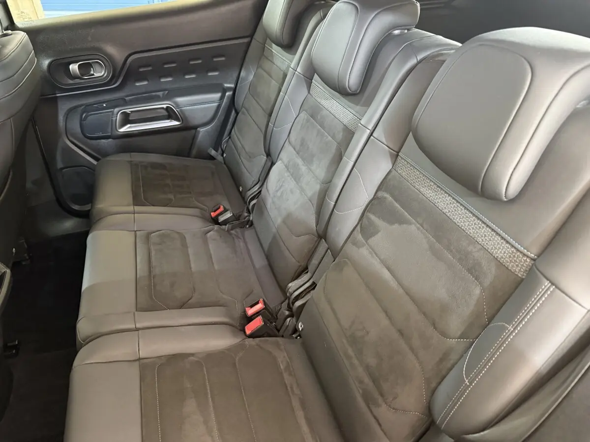 Vue latérale des sièges arrière individuels gris foncé du Citroën C5 Aircross 2023 avec appuie-têtes et ceintures visibles.
