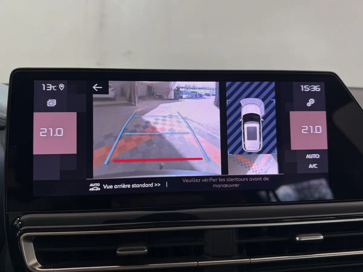 Écran tactile intérieur du Citroën C5 Aircross 2023 montrant la caméra de recul avec guidage et vue aérienne du véhicule gris clair.