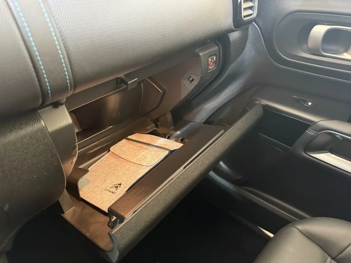 Intérieur de la Citroën C5 Aircross 2023, boîte à gants ouverte avec pochette grise, vue côté passager.