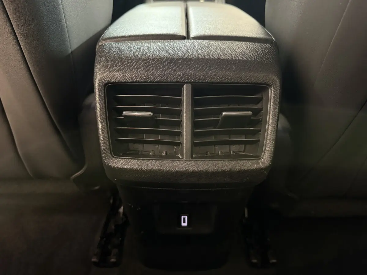 Vue rapprochée des aérateurs arrière noirs et prise USB du Citroën C5 Aircross gris clair, intérieur sombre.