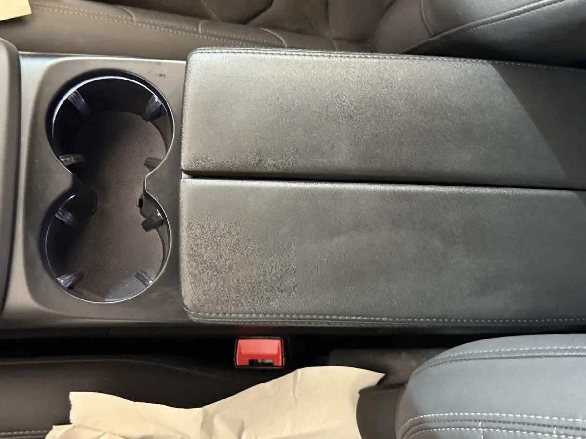 Gros plan sur la console centrale noire avec porte-gobelets et accoudoir du Citroën C5 Aircross gris clair 2023.