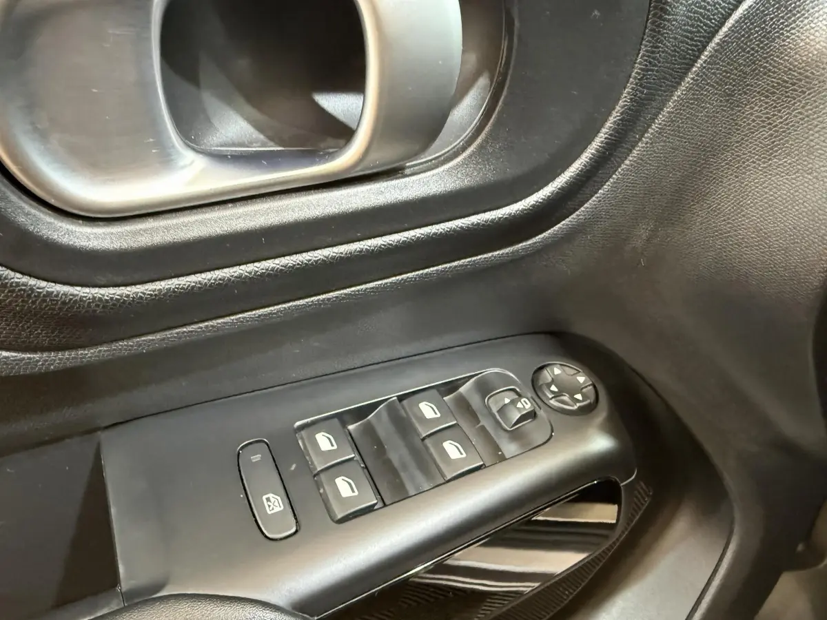 Gros plan sur les commandes de lève-vitres et rétroviseurs côté conducteur d'une Citroën C5 Aircross gris clair 2023.