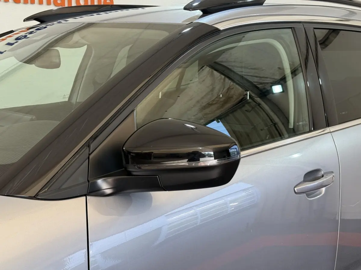 Gros plan sur le rétroviseur droit noir et la porte gris clair d'un Citroën C5 Aircross 2023, vue latérale.