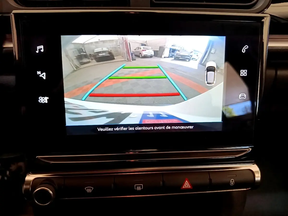 Écran tactile intérieur montrant la caméra de recul avec guidage coloré dans une Citroën C3 blanche de 2021.