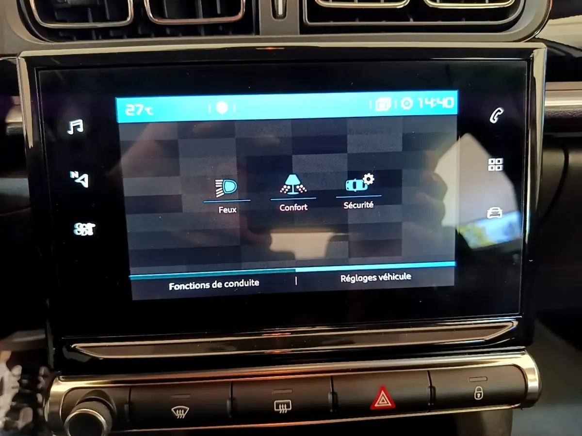 Écran tactile central de la Citroën C3 blanche, affichant les réglages Feux, Confort et Sécurité.