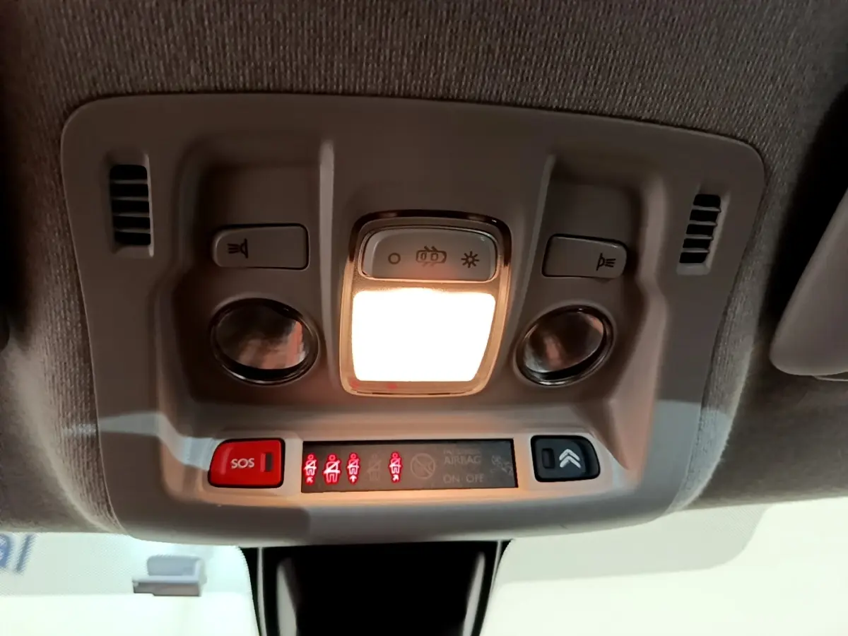 Vue en gros plan du plafonnier intérieur blanc avec éclairage et boutons SOS de la Citroën C3 blanche 2021.
