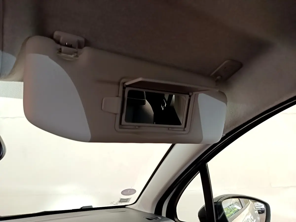Miroir de courtoisie ouvert sur pare-soleil côté conducteur dans l'habitacle d'une Citroën C3 blanche.