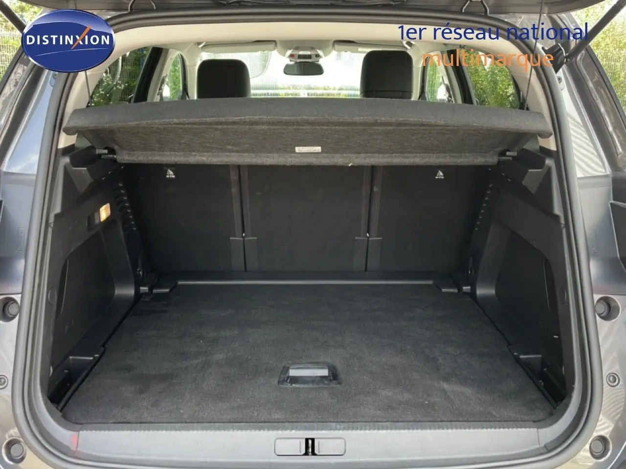 Coffre ouvert d’un Citroën C5 Aircross Hybrid gris platinium, vue arrière montrant l’espace de chargement vide.