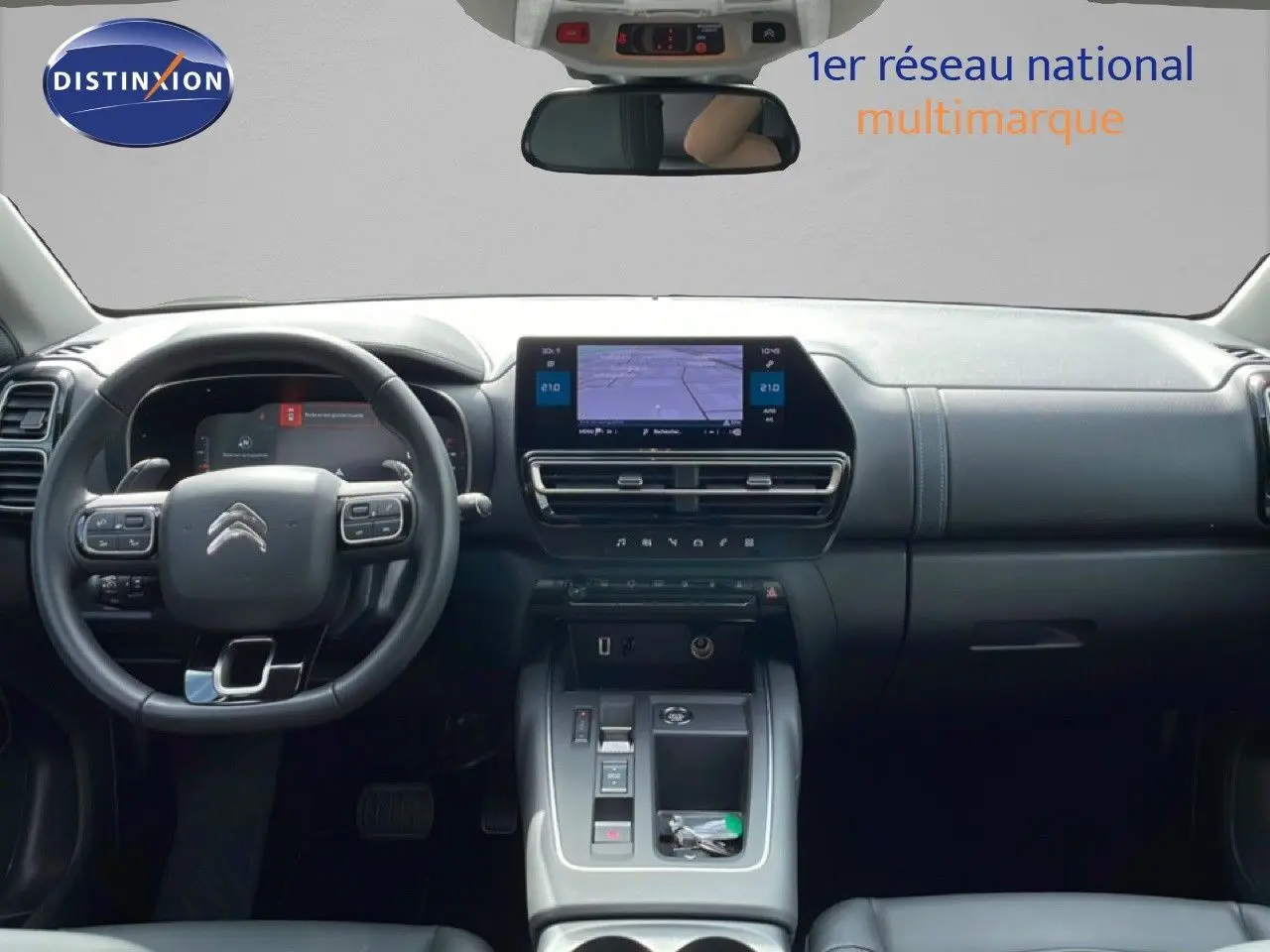 Intérieur avant du Citroën C5 Aircross Hybrid 2025, tableau de bord noir avec écran tactile central et volant multifonction.